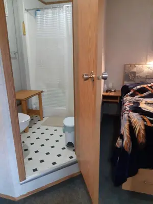 a bathroom with a door open to a bedroom with a toilet at Peace and Quiet in Lac La Biche