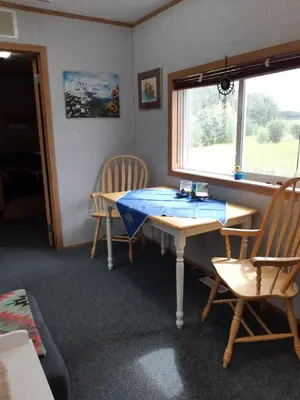 a room with a table and two chairs and a window at Peace and Quiet in Lac La Biche
