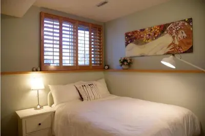 a bedroom with a white bed and a window at OFF CAMPUS UC Room in Calgary