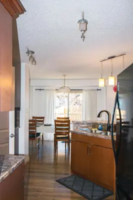 a kitchen with a sink and a dining room at Entire Home AC 4Beds Sleeps 8 Double Garage Near WEM Free Wifi & Netflix in Edmonton