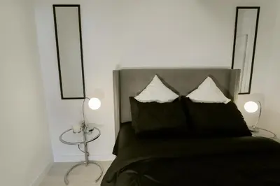 a bedroom with a bed with two pillows and two lamps at Vibrant & Modern Loft-style Walkout Near LRT in Calgary