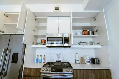 a kitchen with a stove and a microwave at Vibrant & Modern Loft-style Walkout Near LRT in Calgary