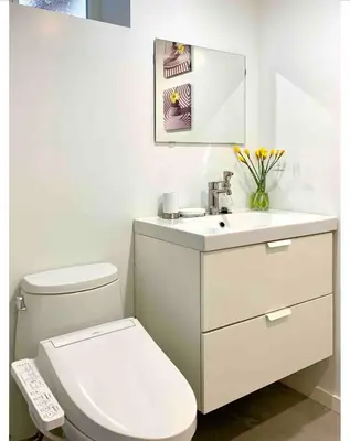 a white bathroom with a toilet and a sink at 3Beds 2BA Cherry Blossom Suite - Free Parking - Central Oakridge Neighbourhood in Vancouver