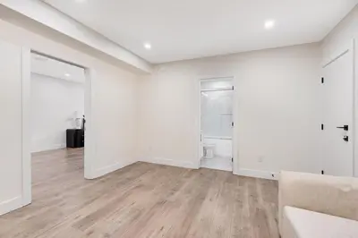 an empty living room with white walls and wood floors at William Place in Surrey