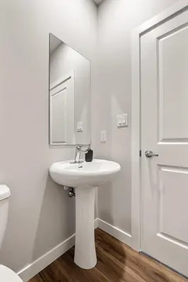 a white bathroom with a sink and a mirror at Serene Peaks, Private Hot Tub, Peaceful in Radium Hot Springs