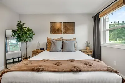 a bedroom with a large bed and a window at Serene Peaks, Private Hot Tub, Peaceful in Radium Hot Springs