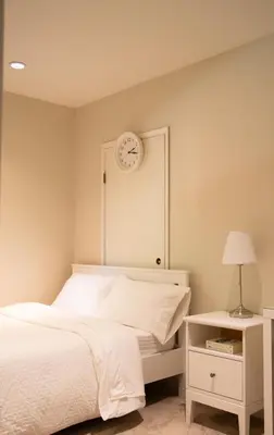 a bedroom with a bed and a clock on the wall at Creek Side 2-Bedroom Guest Suite in Burnaby