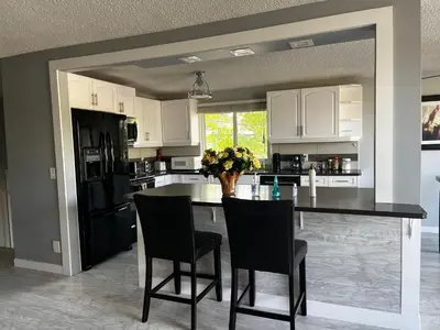 a kitchen with a table with chairs and a counter top at hunter' s new home! in Calgary