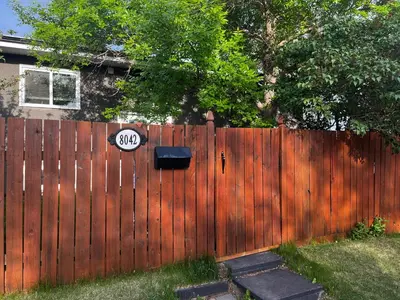 a wooden fence with a speed limit sign on it at hunter' s new home! in Calgary