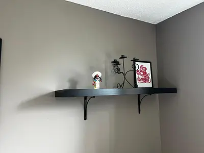 a shelf on a wall with a doll on it at hunter' s new home! in Calgary