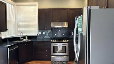 a kitchen with a stove and a refrigerator at Metropolitan Dream Stay with Saltwater Pool and Hot Tub in Surrey