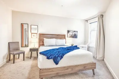 a bedroom with a bed with a blue blanket on it at Canmore Mountain Views -3Beds-Ski Stay Deals in Canmore
