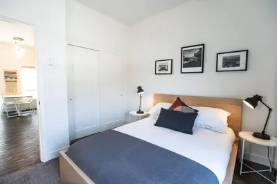 a bedroom with a large white bed and a table at Reved Up & Out - Remarkable Two Bedroom Condo in Revelstoke