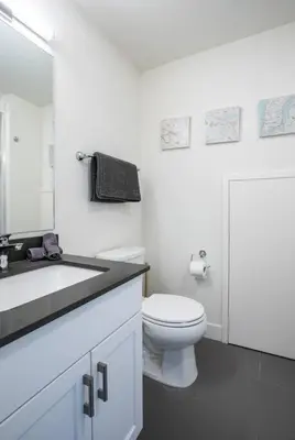 a white bathroom with a toilet and a sink at Reved Up & Out - Remarkable Two Bedroom Condo in Revelstoke