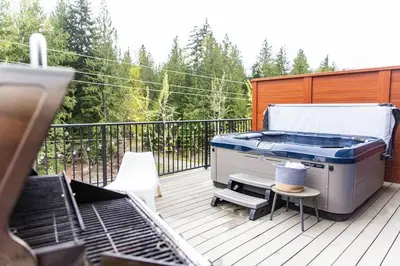 a grill on a deck with a table and chairs at Reved Up & Out - Remarkable Two Bedroom Condo in Revelstoke