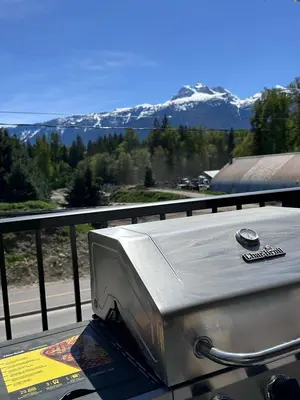 a toaster sitting on top of a balcony with mountains at Revy's Peak Condo - Hot Tub with View in Revelstoke