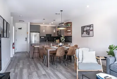 a kitchen and living room with a table and chairs at Revy's Peak Condo - Hot Tub with View in Revelstoke