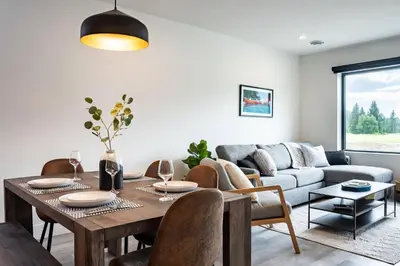 a living room with a table and a couch at Revy's Peak Condo - Hot Tub with View in Revelstoke