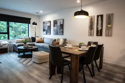 a living room with a table and a couch at Selkirk Staytion - Stylish Condo with Hot Tub in Revelstoke