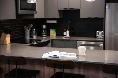 a kitchen with a counter with an open book on it at Selkirk Staytion - Stylish Condo with Hot Tub in Revelstoke