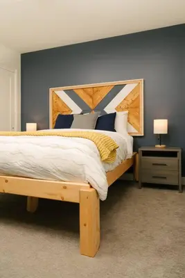 a bedroom with a large bed with a wooden headboard at The Nest - Condo with Hot Tub & BBQ in Revelstoke