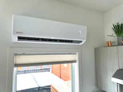 a ceiling fan in a room with a window at The Nest - Condo with Hot Tub & BBQ in Revelstoke