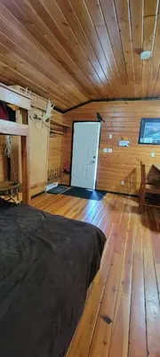 a bedroom with a bed and a wooden floor at Bone Creek Wilderness Retreat in Blue River