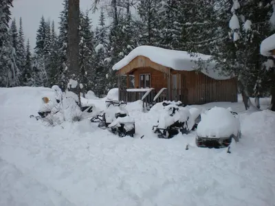 a cabin covered in snow in front at Bone Creek Wilderness Retreat in Blue River