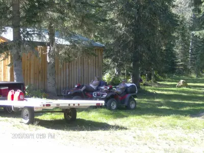 two people riding on atvs on a trailer at Bone Creek Wilderness Retreat in Blue River