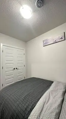 a bedroom with a bed and a ceiling at The Cozy Nest in Calgary