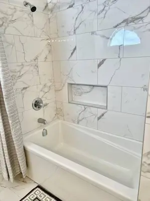 a white bathroom with a white tub and marble walls at Crescent Heights Majesty in Calgary