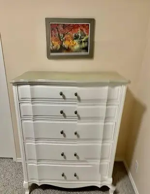 a white dresser in a room with a painting on the wall at Crescent Heights Majesty in Calgary