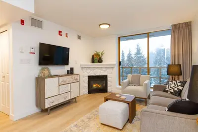 a living room with a couch and a fireplace at Renovated 1Bed-1Bath in Village with Pool, Hot Tub, and Sauna in Whistler