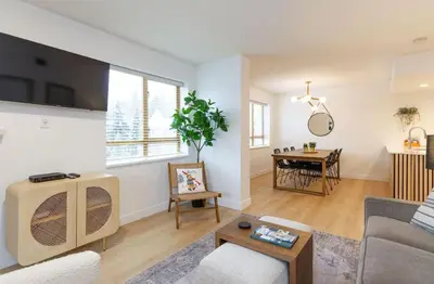 a living room with a couch and a table at Renovated 2Bed-2Bath in Village with Pool, Hot Tub, and Sauna in Whistler