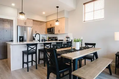 a kitchen and dining room with a table and chairs at New! Luxury, Top Floor, Ski in/Ski Out, Private Hot Tub and Mountain Views in Sun Peaks