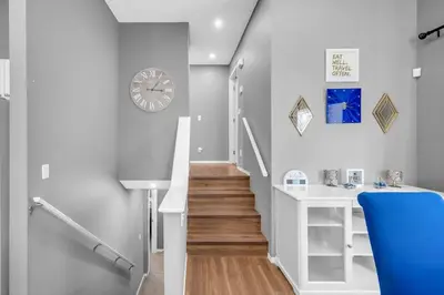 a stairway with a clock on the wall and a stair case at 12 Spacious Home W Ac, Crib, Garage, By Airport in Calgary