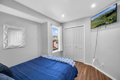 a bedroom with a blue bed and a flat screen tv at 12 Spacious Home W Ac, Crib, Garage, By Airport in Calgary