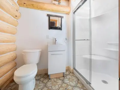 a bathroom with a toilet and a glass shower at Golden Cabin - Hot Tub - Games Barn - Theatre in Golden