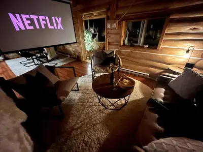 a living room with a television and a table and chairs at Golden Cabin - Hot Tub - Games Barn - Theatre in Golden