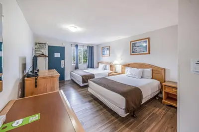 a hotel room with two beds and a television at Bluebird Motel in Nanaimo