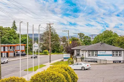 a white car parked in front of a house at Bluebird Motel in Nanaimo