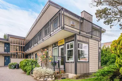an apartment building with a balcony on top of it at Bluebird Motel in Nanaimo