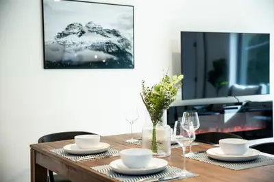 a table with plates and glasses and a picture on the wall at Ski & Tee Retreat Bright Three Bedroom and Hot Tub in Revelstoke