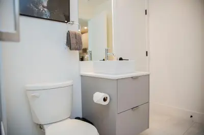 a white bathroom with a toilet and a sink at Ski & Tee Retreat Bright Three Bedroom and Hot Tub in Revelstoke