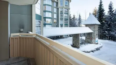 a balcony of a building with snow on the ground at Woodrun Lodge 217 | Ski-In Ski-Out Condo - Walk to Upper Village w/ Hot Tub, Pool + Free Parking in Whistler