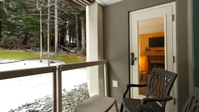 a screened in porch with a chair and a window at Woodrun Lodge 214 | Ski-in-Ski-Out Condo, Heated Pool, Hot Tub, Gym in Whistler
