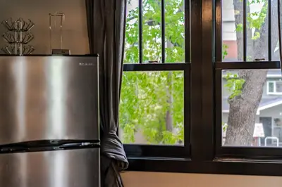 a stainless steel refrigerator in front of a window at Historical Building 1br 1ba Walk To Rogers Place in Edmonton