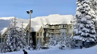 a snow covered building with a snow covered roof at Woodrun Lodge 412 | Ski-In-Ski-Out, Pool, Hot Tub, & Free Parking in Whistler