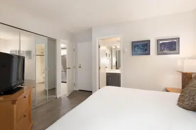 a bedroom with a large bed and a television at Woodrun Lodge 412 | Ski-In-Ski-Out, Pool, Hot Tub, & Free Parking in Whistler
