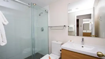 a bathroom with a shower and a toilet and a sink at Woodrun Lodge 211 | Ski-In Ski-Out Condo w/ Heated Pool, Hot Tub, Parking, & Gym in Whistler